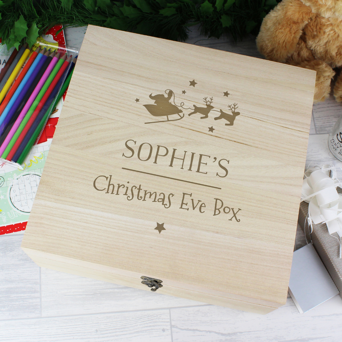 personalised wooden christmas eve box with the child's name engraved on the lid below a santa and reindeer image