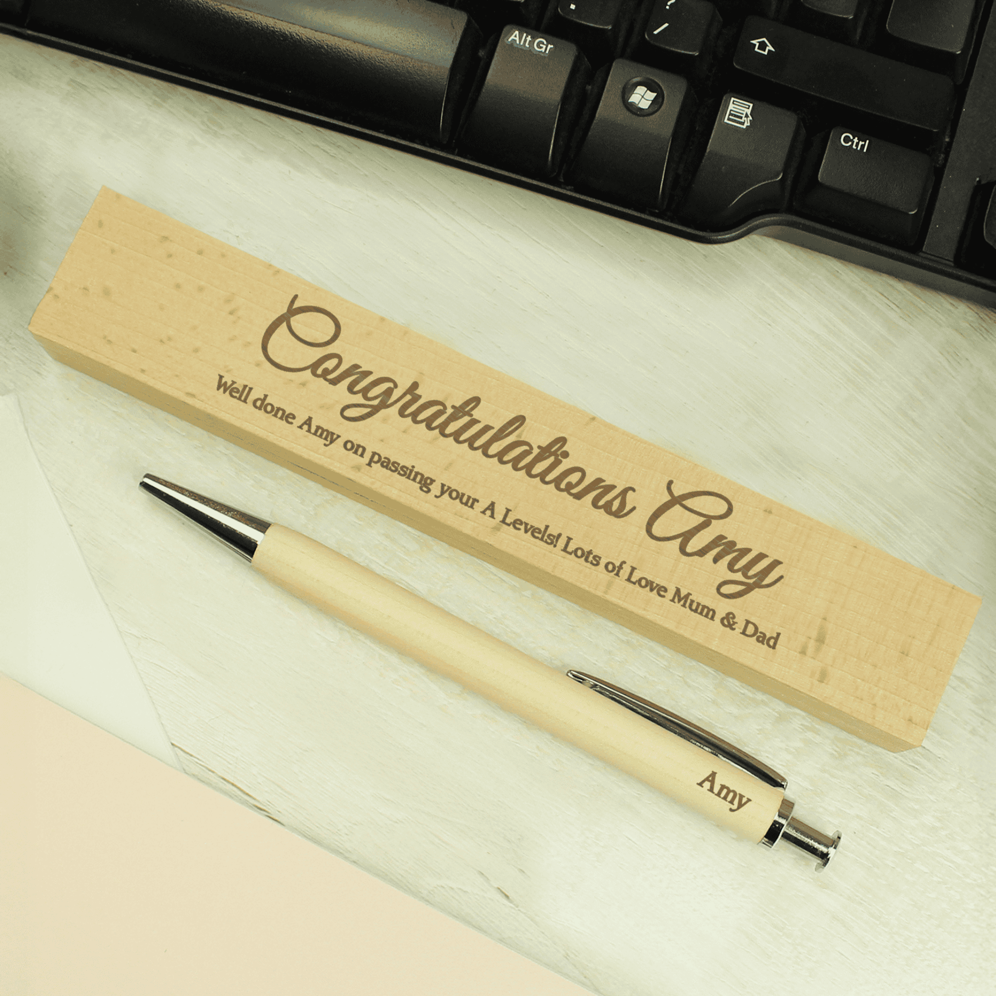 personalised wooden pen box set engraved with a message over 2 lines on the box and a name on the pen
