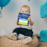 A toddler holding their own personalised birthday book