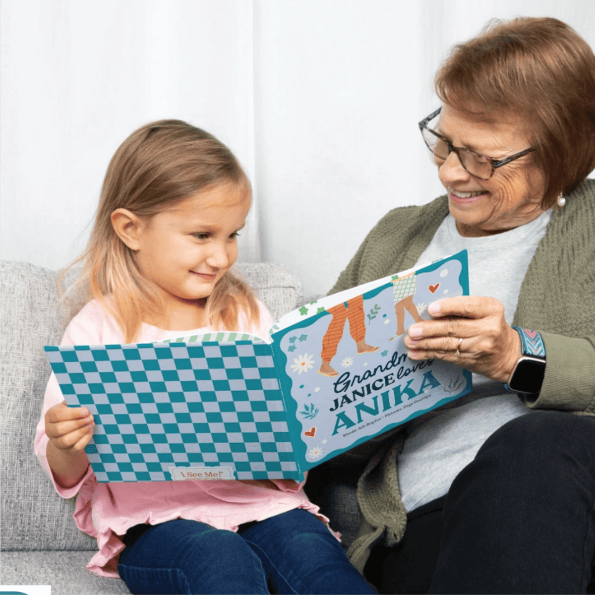 A child reading the personalised book Granny loves me with her Gran