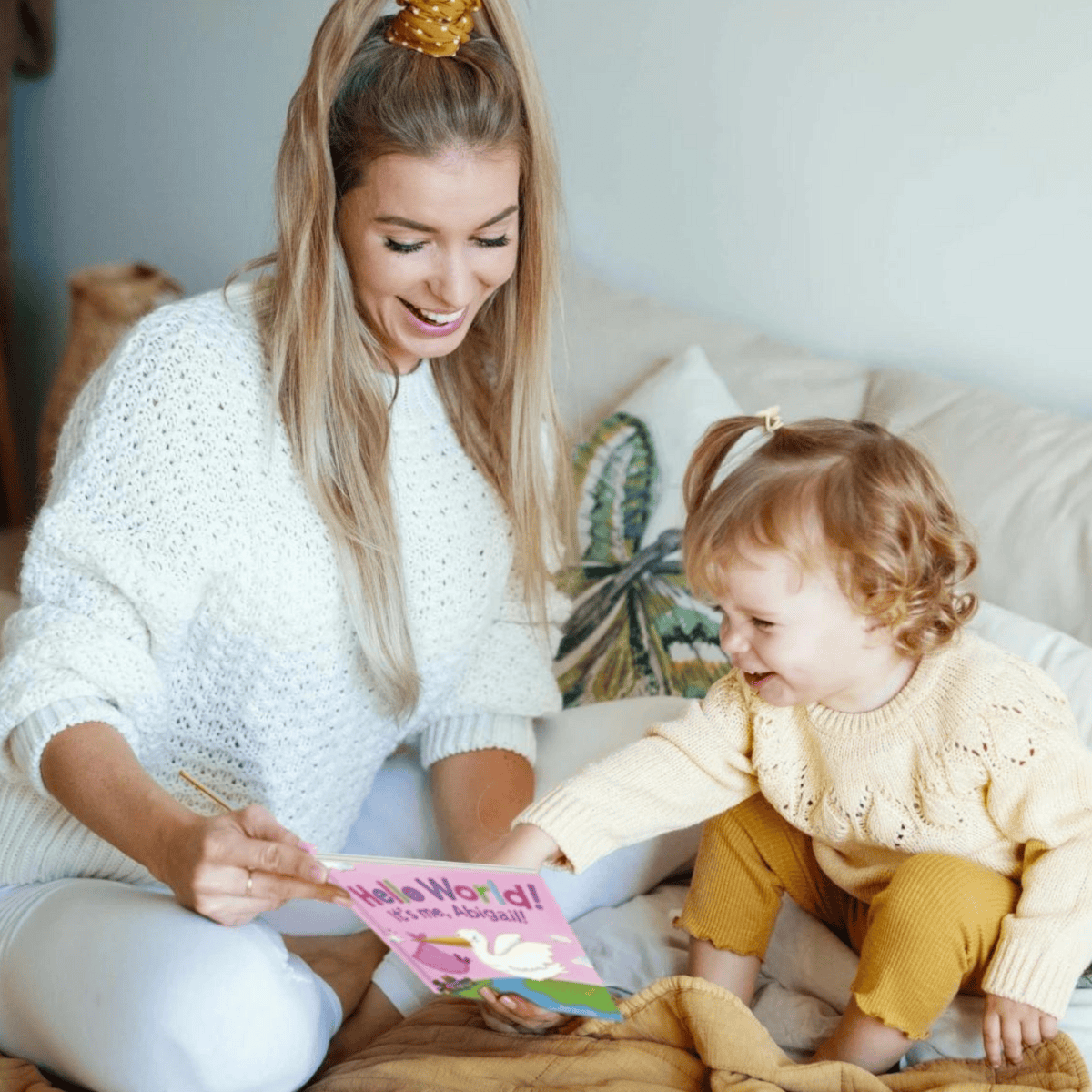 Woman and child reading Hello World personalised book on a couch