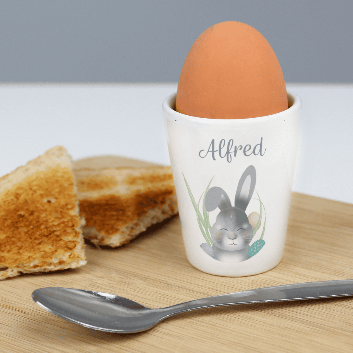 white ceramic easter bunny egg cup showing the personalisation on the front above the bunny design
