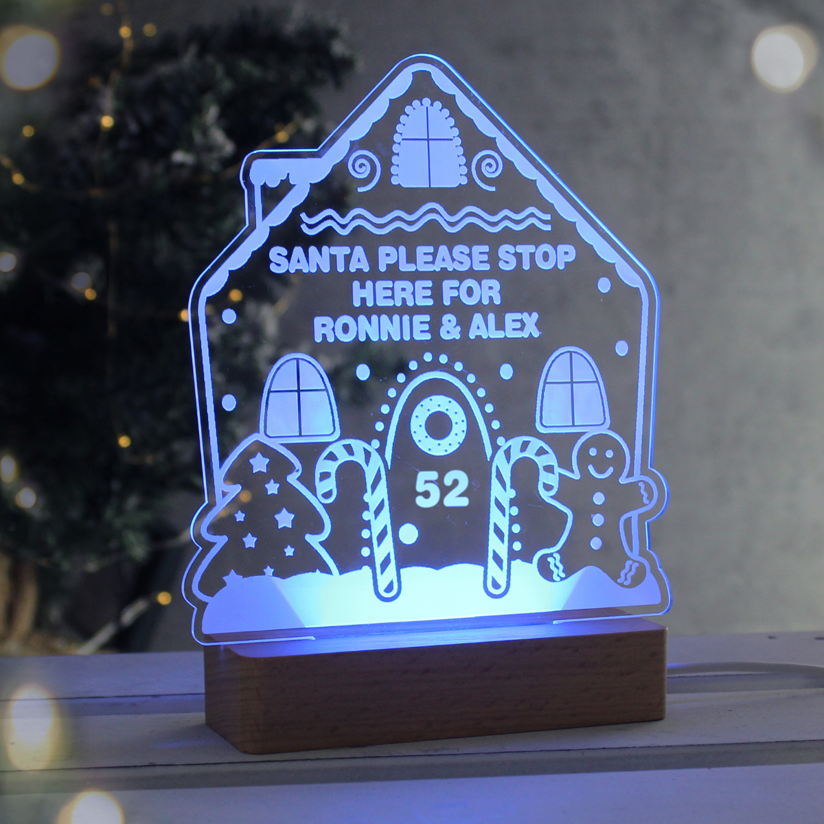 personalised gingerbread LED house showing it lit up in blue