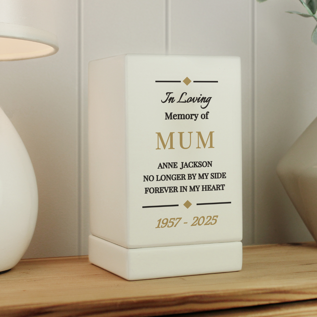 personalised white wooden urn with the personalisation on the front in black and gold writing