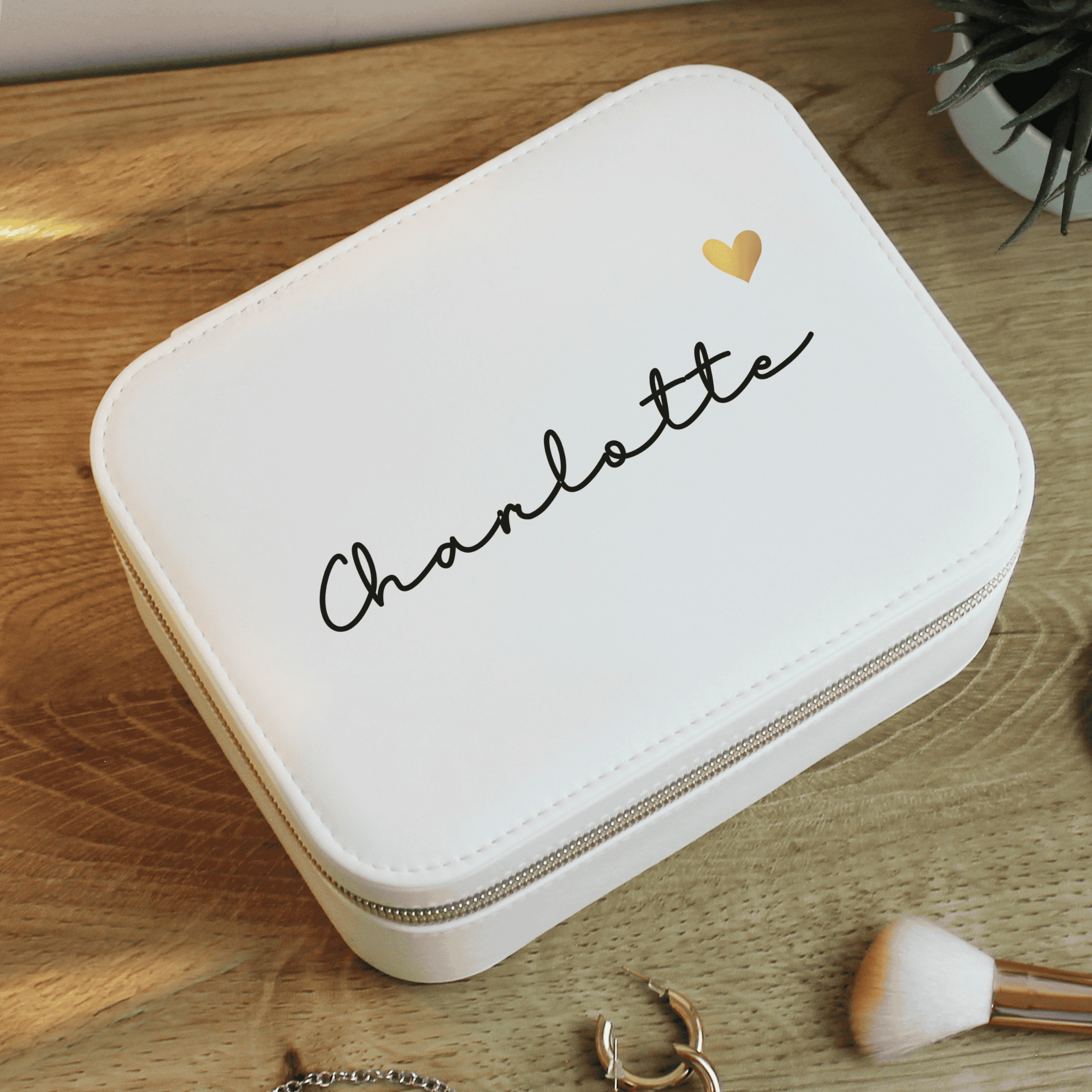 personalised white travel jewellery box with a name on the top in black writing and gold heart beside it