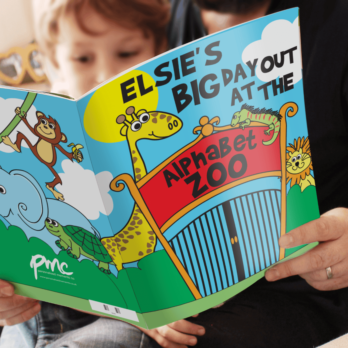 a child holding the personalised zoo story book. 