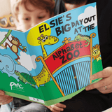 a child holding the personalised zoo story book. 